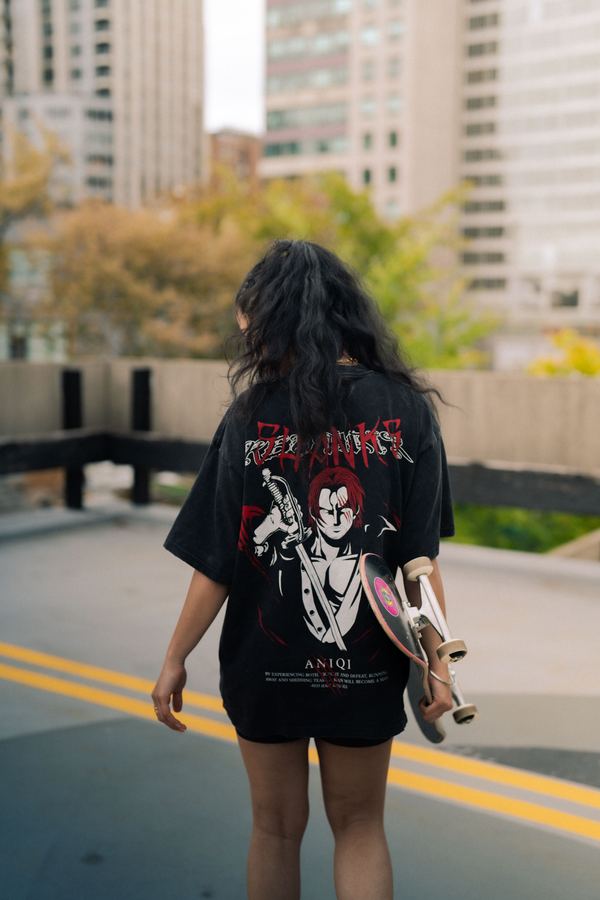 Model wearing an oversized graphic streetwear T-shirt while holding a skateboard — KDG Finds clothing category, South Africa