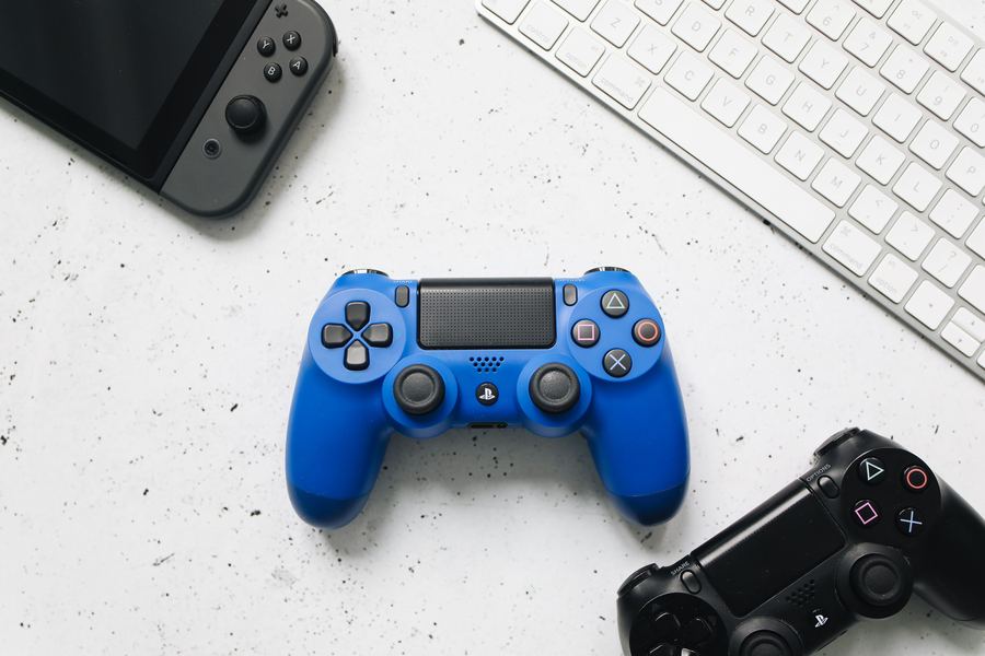 Blue and black PlayStation controllers next to a keyboard and handheld console — KDG Finds tech and gadgets category, South Africa